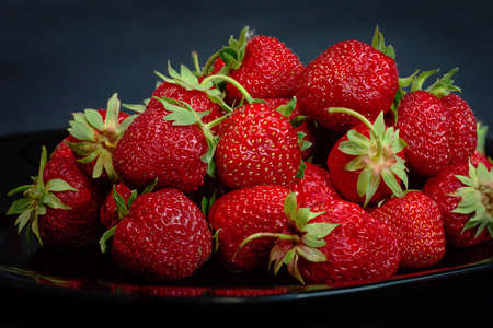 Strawberry closeup. Macro image of fresh strawberries on dark backgroundの写真素材