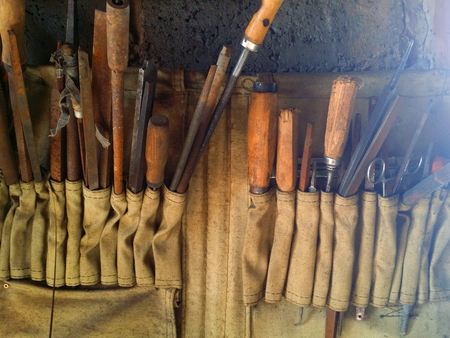 Tooling in old dirty beige rag rack on concrete wallの写真素材