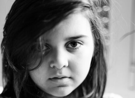 portrait of a beautiful girl in black and white with a deep looking perhaps a little sad because of the confinement due to the coronavirusの写真素材