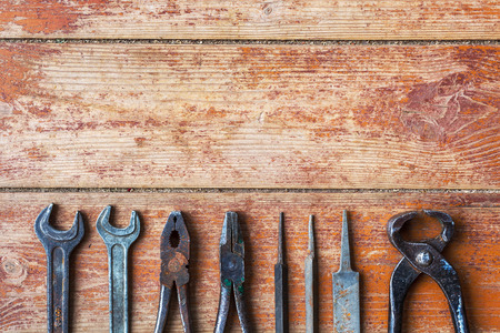Older tools are laid out in a row on background of the old wooden floorの写真素材