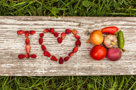 Healthy diet. Strawberries are laid out in the letters on a background of green grass and board.の写真素材