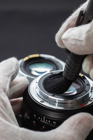 man cleans the lens from accumulated dirt and dustの写真素材