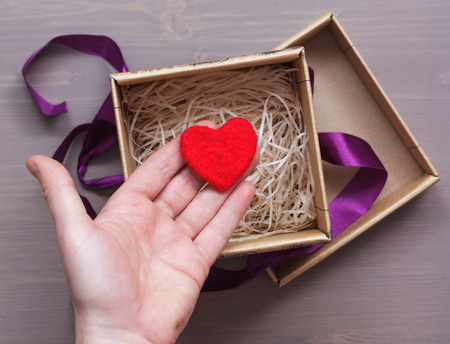 man hiding in a gift box red heart