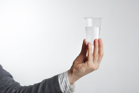 Man holding a disposable plastic cup with water.の写真素材