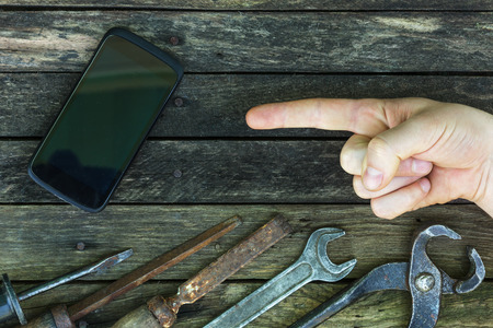 Repair phone using tools. Old workshop with new technologies. The background for the carpentry work.の写真素材