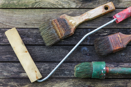 Dried paint in old brush for repair. Vintage tools on a wooden surface