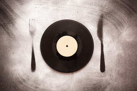 Vinyl record in the form of plates on the silhouette fork and knife. Good taste in musicの写真素材