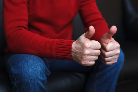 Man showing thumbs up. Approval of the selection, success at workの写真素材