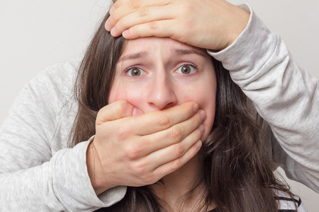 Domestic Terror: guy covers her mouth girl. She in fear looks at the cameraの写真素材