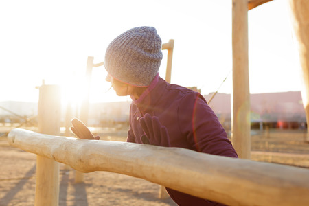 The girl warming up in the morning before jogging. She looks toward the sunlight.の写真素材