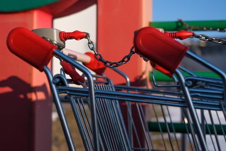 Two shopping carts connected by a chainの写真素材