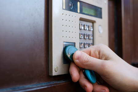 The girl opens the front door with a magnetic tablet. Doorphone as a means of security against...
