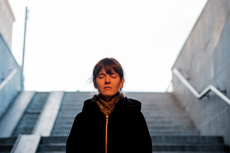 The girl goes down the stairs in the underpass. She is afraid to go there alone.の写真素材