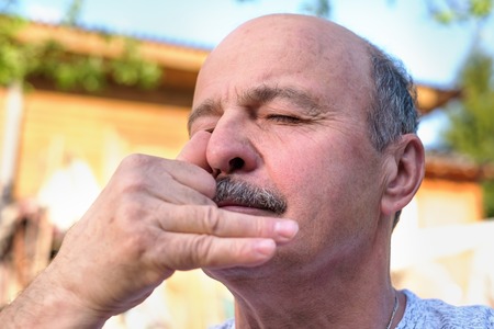 Handsome mature man breathing yoga pranayama on summer sunny day outside.の写真素材