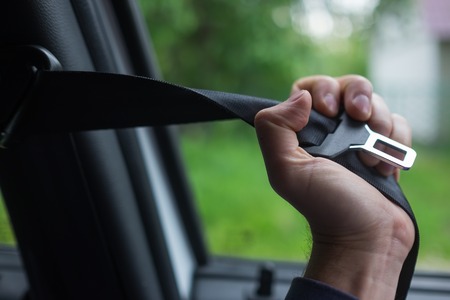 Man hand fastening seat belt in carの写真素材