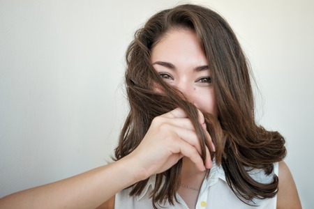 Shy girl hiding her face with hairの写真素材
