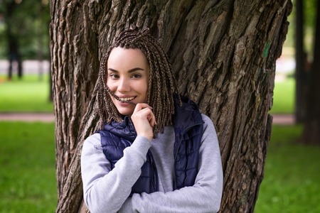 Portrait of a positive teenage girl with braided plaits. She smiles broadly and looks confidentlyの写真素材