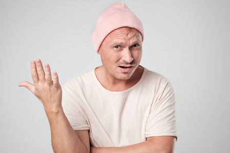 Shot of stylish young caucasian man shrugging shoulders gesturing with hands.の写真素材
