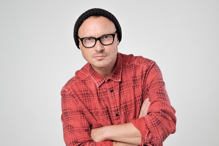 Smiling young man in red shirt standing against white backgroundの写真素材
