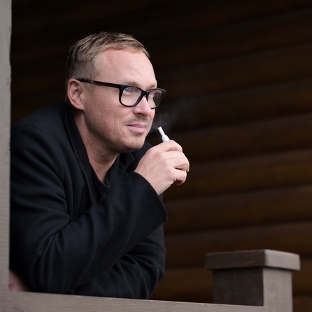 Caucasian man smoking modern hybrid cigarette device outdoorの写真素材