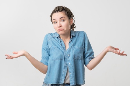 Portrait of caucasian girl with braids having doubtful and indecisive face expression. Confused...