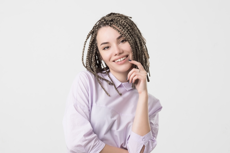 Woman smiling with perfect smile and white teeth. Her hair made in african braids. Confident facial...