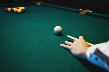 American billiard. Man playing billiard, snooker. Player preparing to shoot, hitting the cue ball.の写真素材