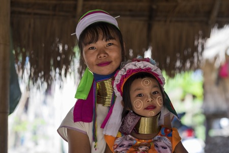 CHIANG RAI, THAILAND - NOVEMBER 4 2017: Unidentified Long Neck Karen hill tribe people. Mother anf daughter smiling at camera. A unique mountain tribe in the tourist villageのeditorial素材