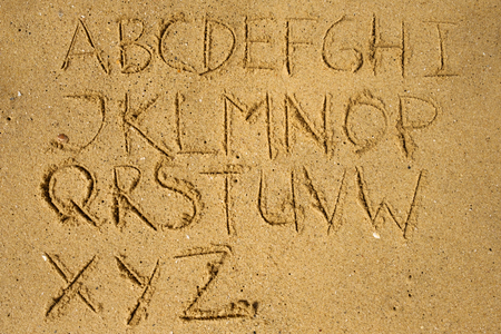 Alphabet as text on sand on the beach. Study during summer holidaysの写真素材