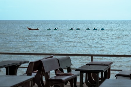 View of the sea and an empty restaurant. Table and chairs without visitors. An unpopular place or...