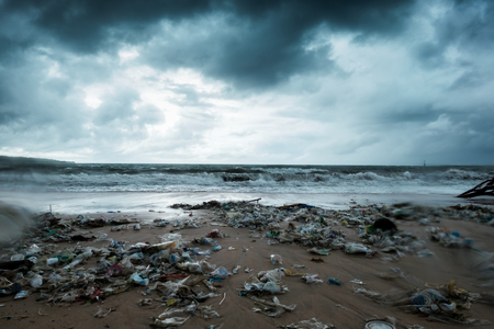 Garbage on beach, environmental pollution in Bali Indonesia. Storm is coming on background. And drops of water are on camera lens. Dramatic viewの写真素材