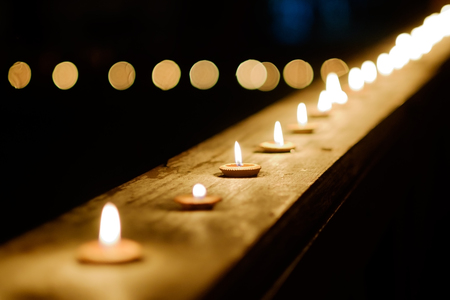 Burning candles in Thai style. Candle light in row at night time during Loy Krathong Festival Chiang Mai, Thailand.の写真素材