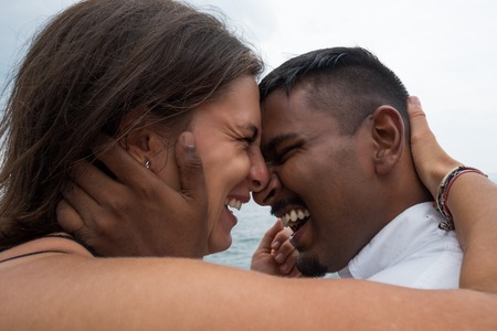 beautiful couple laughing. Close up portrait of asian man and caucasian womanの写真素材