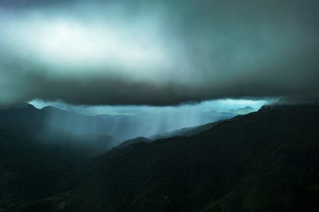 Dramatic view in the mountains during heavy rain in Sri Lanka. There are very dark clouds and streams of rain.の写真素材