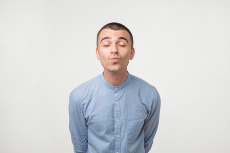 Handsome latin man ready to be kissed. Close up portrait on gray background. Focus on lips.の写真素材