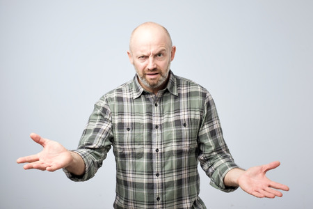 Mture european man dissatisfied frowns and looks sullenly. What do you mean concept. Will you return me my money. Studio shootの写真素材