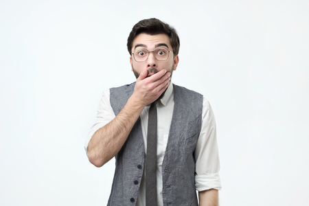 I can not believe you. Good looking young man in casual wear covering mouth with hand and looking at camera.の写真素材