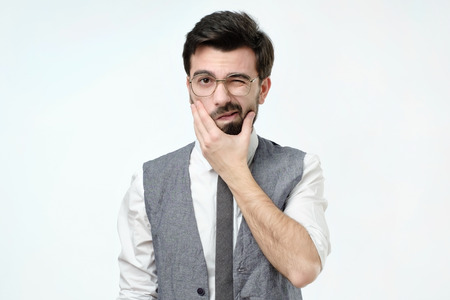 Doubtful bearded young spanish man looking with mistrust. Negative human emotionの写真素材