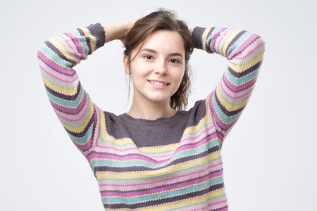 Beautiful young smiling woman in multi colored sweater. Positive human emotionの写真素材