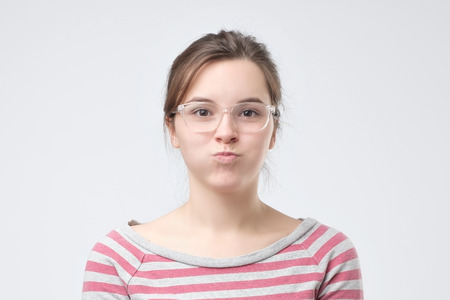 Cute pretty woman blowing her cheeks with pleasure having fun. Beautiful woman having good mood...