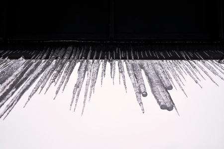 Long icicles fall from the roof on winter and early spring. It is a danger to people.の写真素材