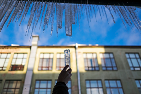Long icicles fall from the roof on winter and early spring. It is a danger to people.の写真素材