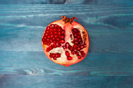 Fresh india pomegranate on blue wooden backgroundの写真素材