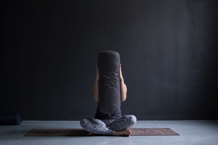 European woman doing yoga at studio hiding her face with bloster.の写真素材