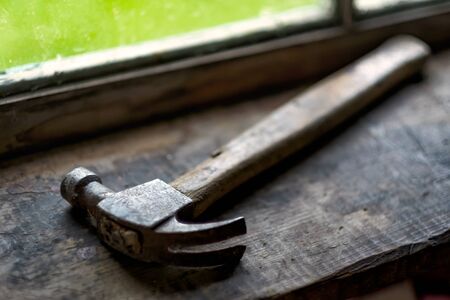 Hammer near window. Tool for carpentry work.