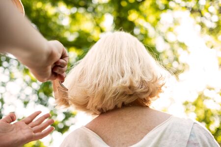 Woman doing an haircut to her grandmotherの写真素材