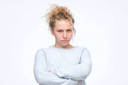 Girlfrowning her face in displeasure, keeping arms folded.の写真素材