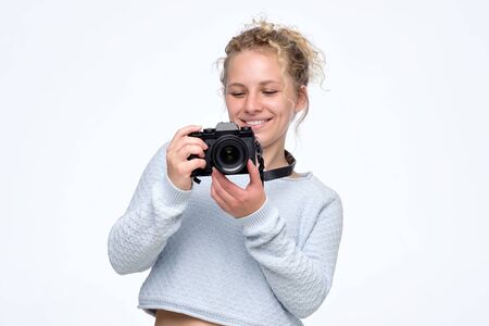 Amazed young pretty woman holding camera studying to make photo.の写真素材