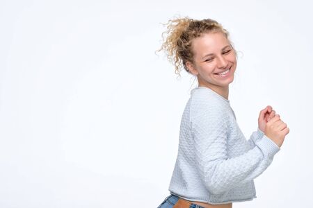 Happy young blonde curly woman with big smile has turned backの写真素材