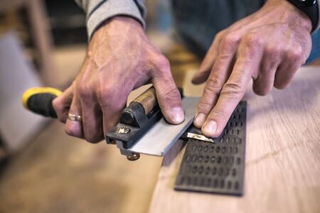 Carpenter sharpening a chisel close up viewの写真素材